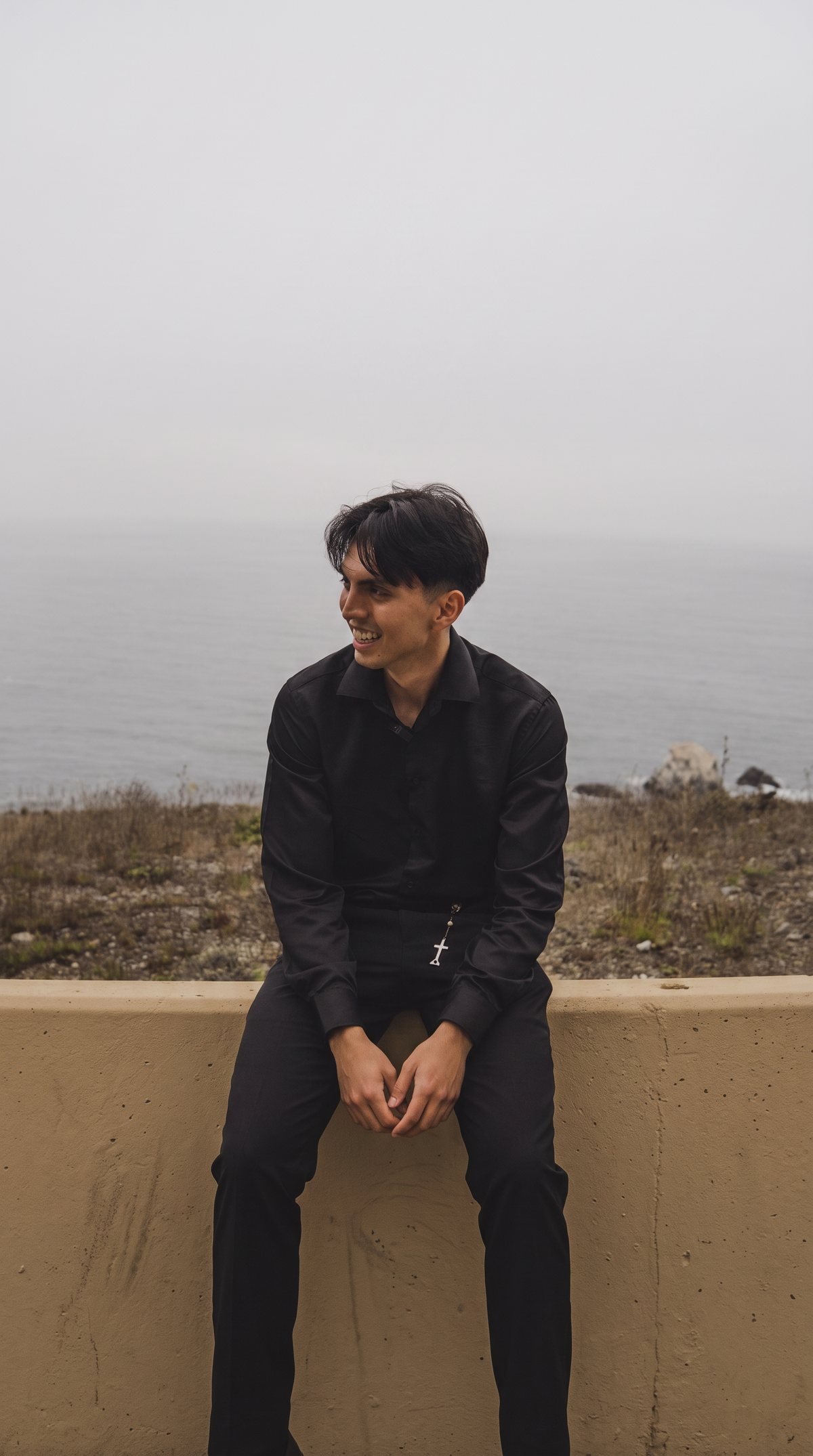 Franco Aurelio sitting on a wall above the sea